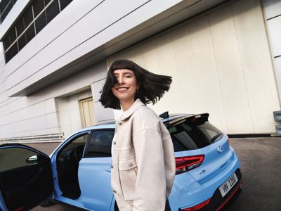 a young woman smiling as she gets ready to drive her new i30 N performance hatchback.